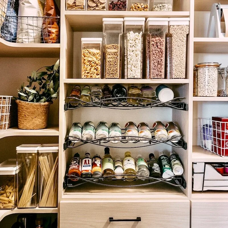 A beautifully organized pantry with woven baskets and labeled jars